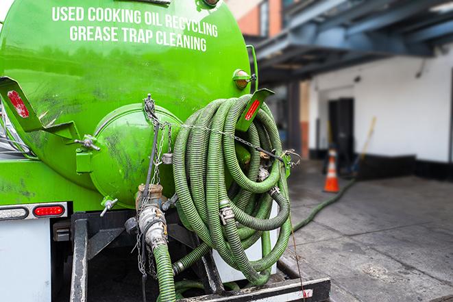 a large grease trap being pumped by a specialist in Alloway